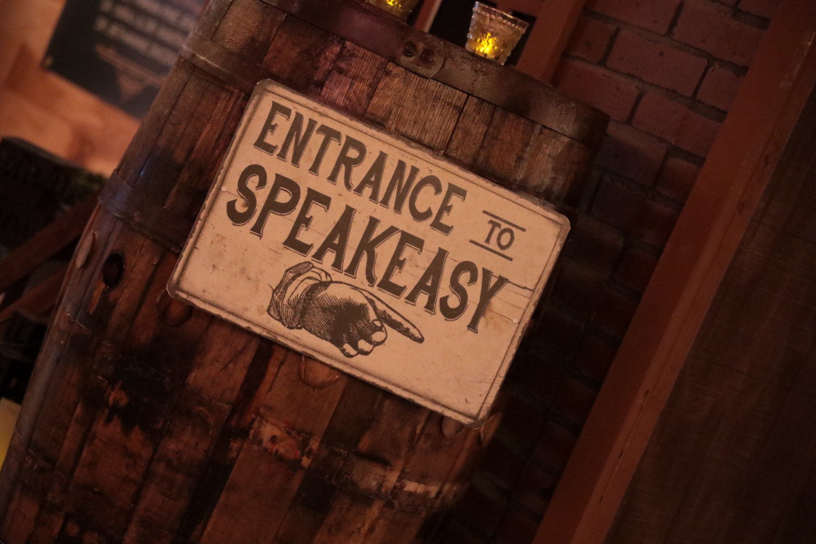 Entrance to speakeasy sign on a wooden bourbon barrel