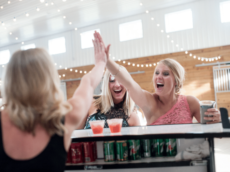 Female bartender giving a high five to wedding guests at The Stables in Whitehouse, OH