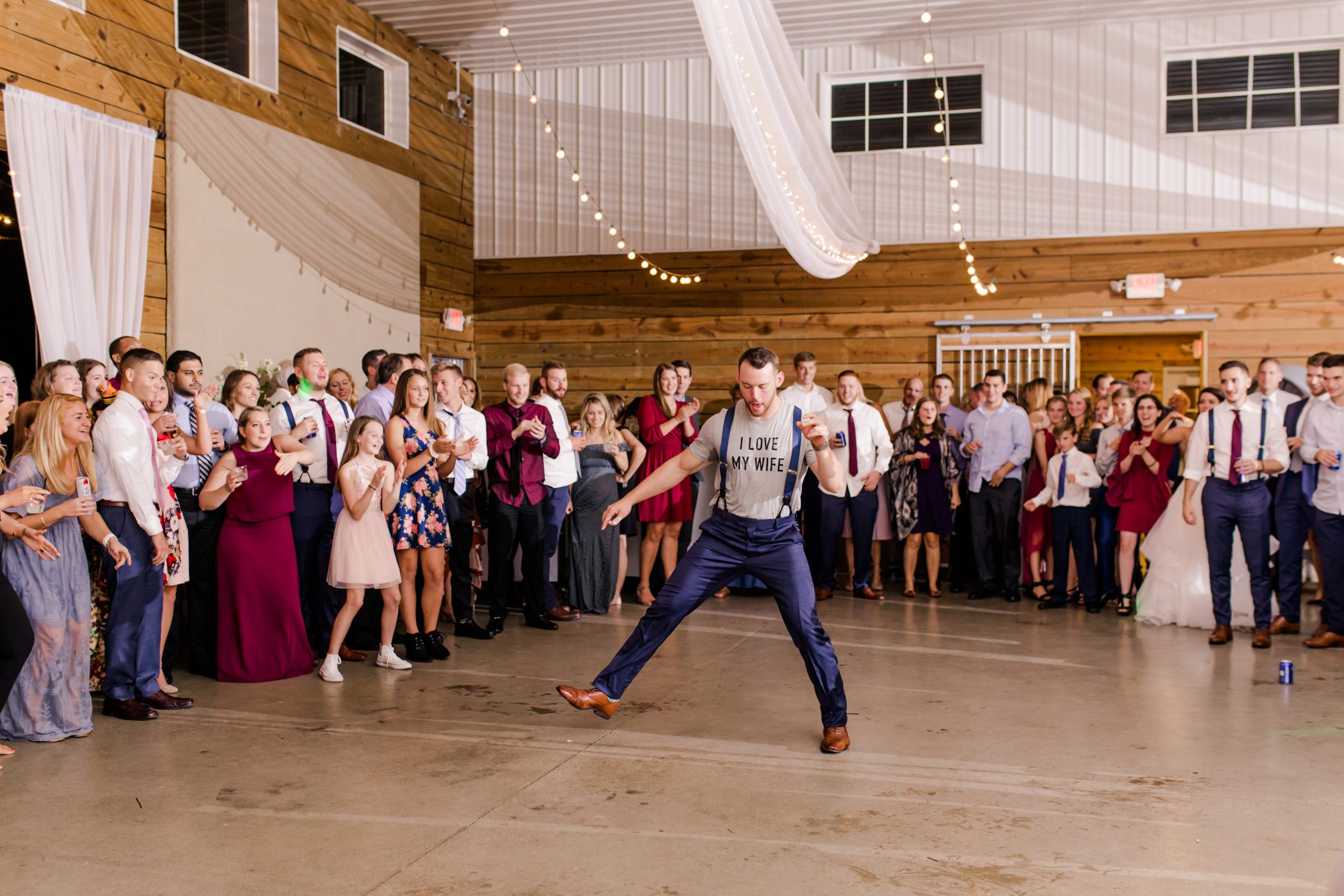 Groom dancing at The Stables on Obee with "I Love My Wife" shirt and suspenders on