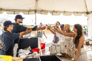 Group of people toasting to the beginning of Barefoot at the Beach 2024 at Maumee Bay State Park