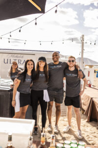 Group of bartenders posing behind the bar during Barefoot at the Beach