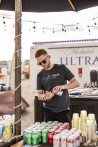 Male bartender pouring soda into a cup at Barefoot at the Beach