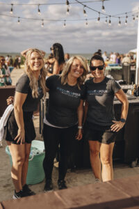 Group of female bartenders posing and smiling for the camera behind the bar at Barefoot at the Beach