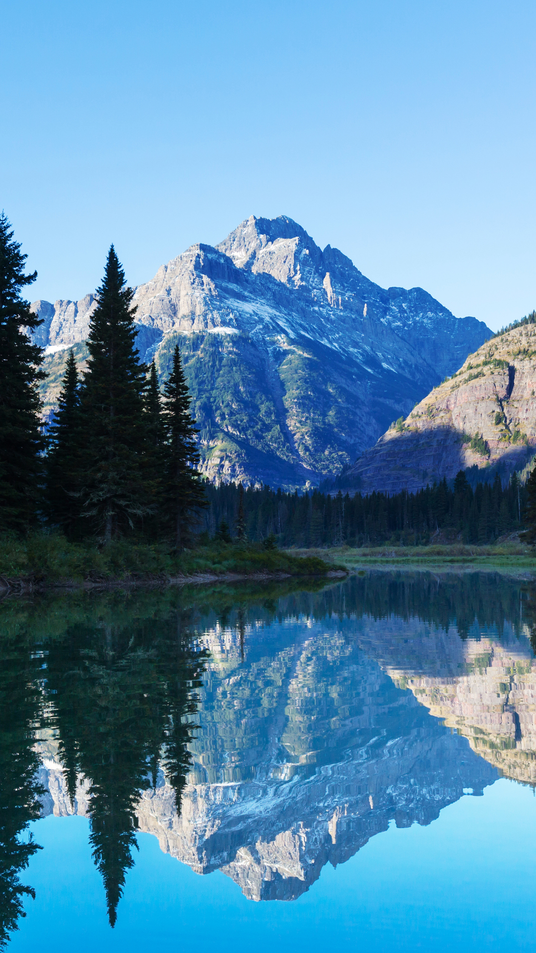 A crystal clear lake with mountains in the background where our company can provide bartending services in the Bozeman and Big Sky areas of Montana